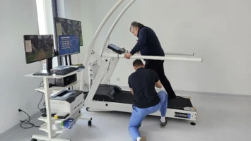 pacjent na bieżni z podwieszeniem